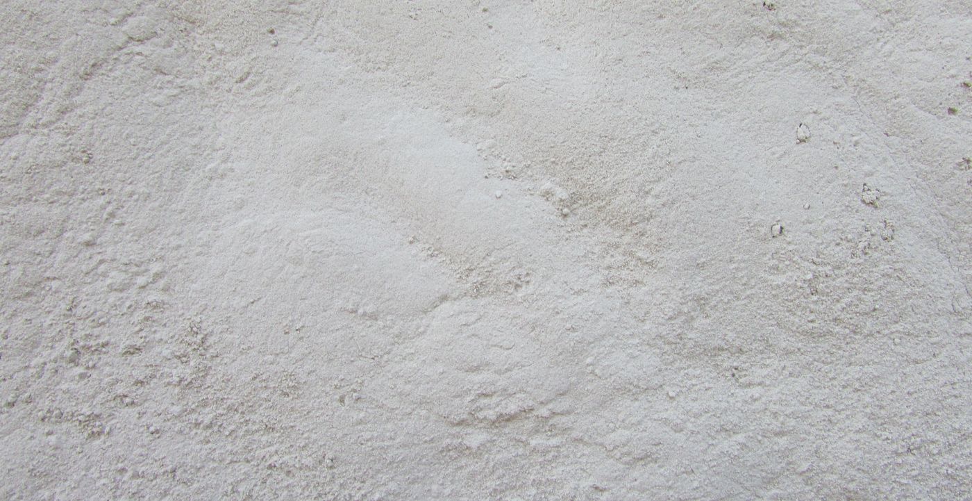 Image: poudre de roche finement broyée, gris clair et étalée sur une surface plane